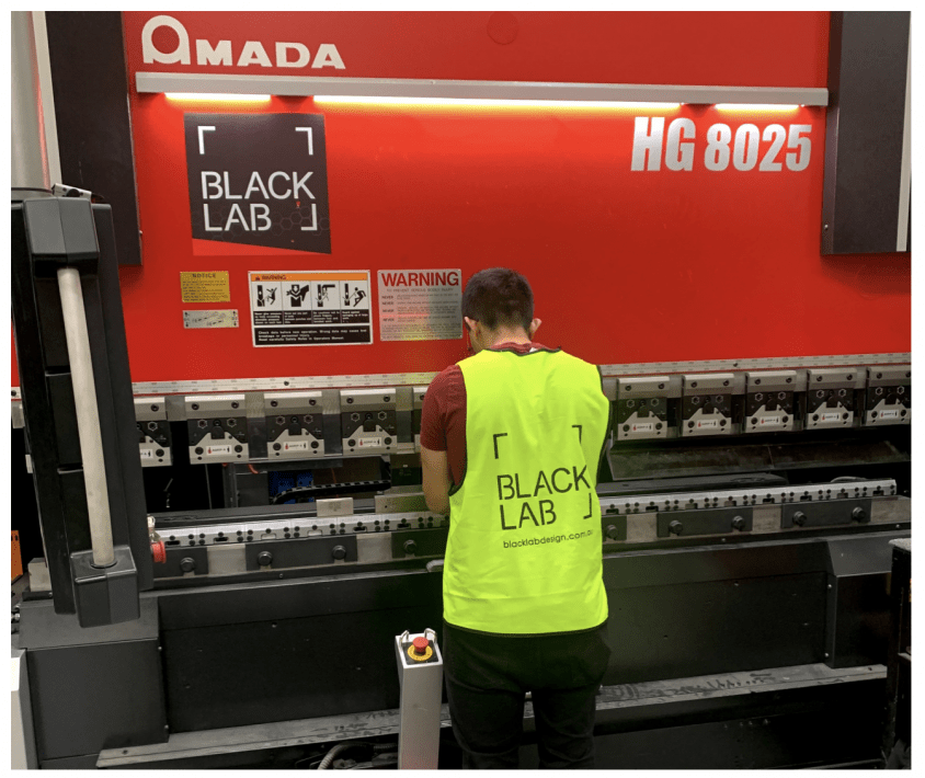 man bending metal on amada machine