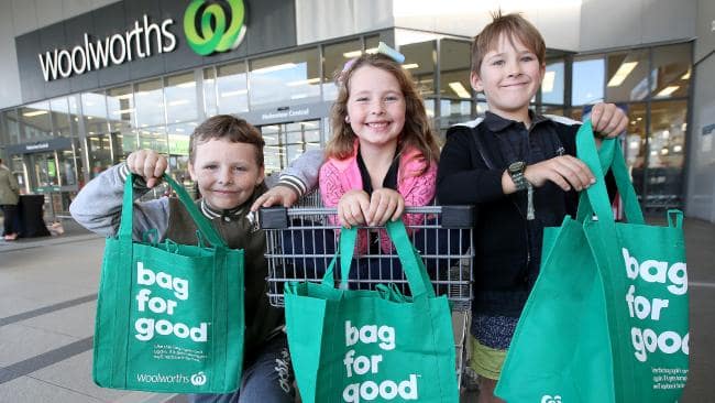 three kids holding woolworths sustainable bags